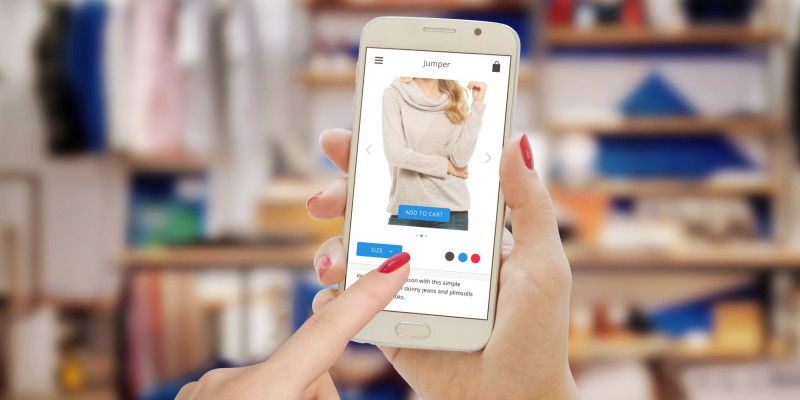 Leitfaden für mehr Umweltfreundlichkeit im Onlineshop Auf dem Bild sieht mein eine Hand, die ein Smartphone hält, auf dem ein Online-Kleidungsshop aufgerufen wurde.